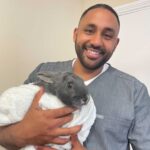 Dr Bobby Ortiz, small and exotic pet vet, posing with a bunny patient