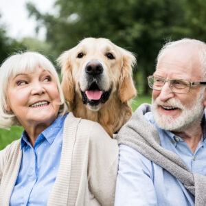 happy older dog with senior couple