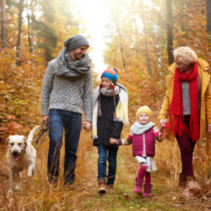 family with dog out for a walk in a wooded area